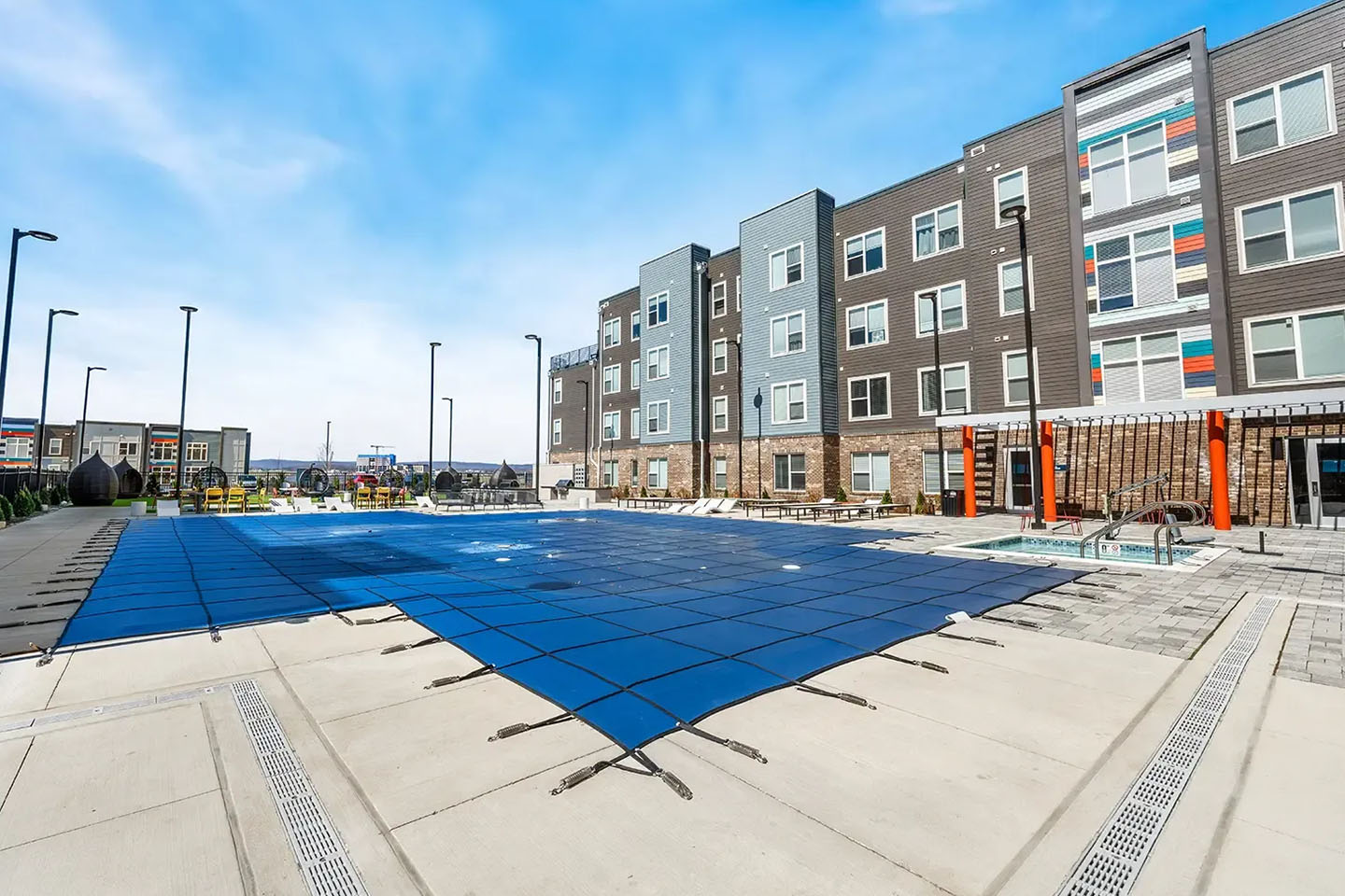 Pool next to apartment complex with protective covering.